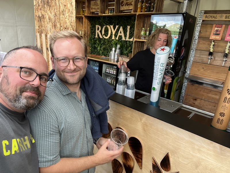 Christian og en ven ved en Royal-bar med fadølshaner og stablede plastkrus